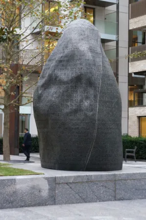 large dark boulder with engraved inscriptions in various languages