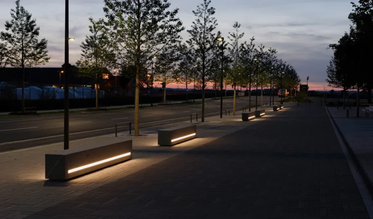 night view of several benches in a park with integrated LED strips