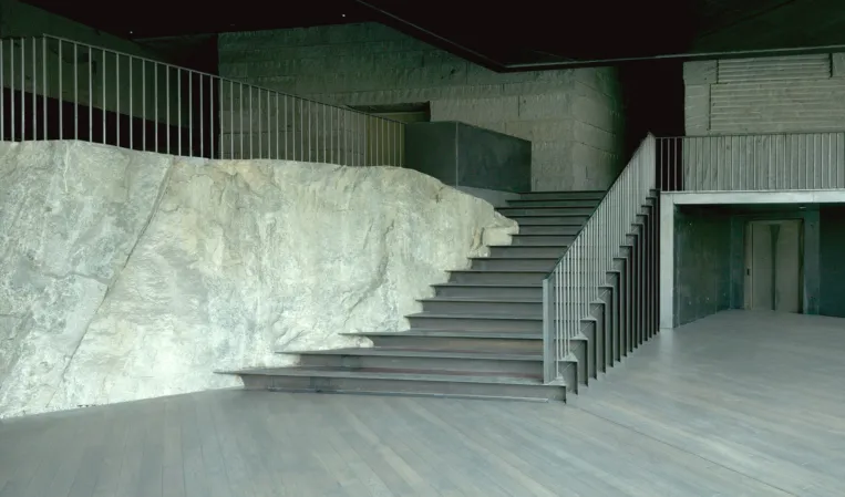 large room with rock in the center and integrated staircase