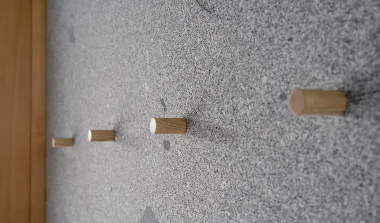 solid granite wall with wooden hooks
