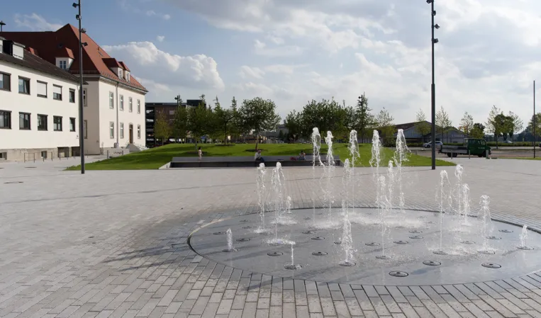fountain field integrated into a large forecourt paved with granite