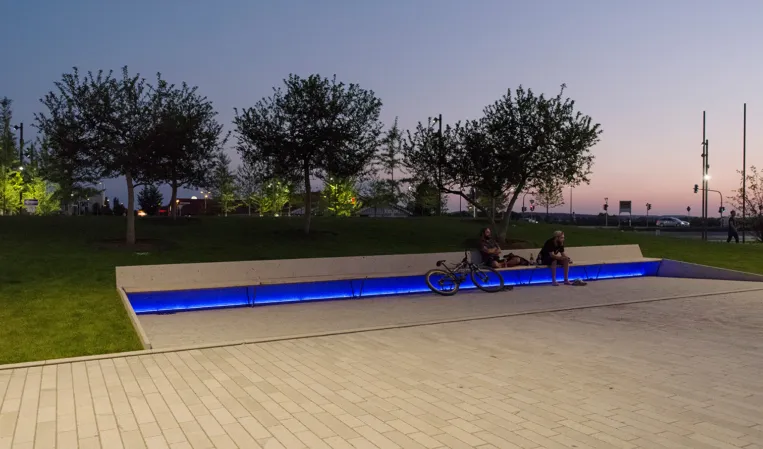 night photo of a park with view of a bench with blue lighting