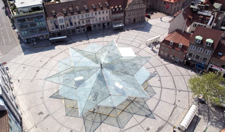 large town square with star-shaped paving and a star-shaped glass roof construction