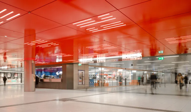 light granite flooring in a subway station with red ceiling elements