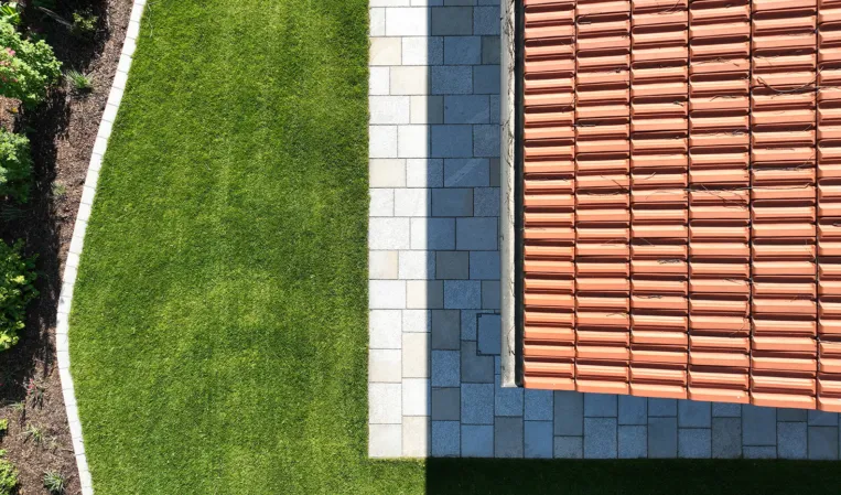 Drone footage of a garden with paving around the house