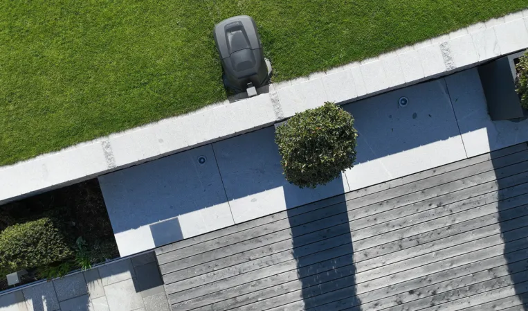 Drone footage of a garden with a stone wall