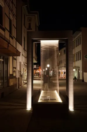 Brunnenanlage mit intergrieten Wasservorhang bei Nacht fotografiert