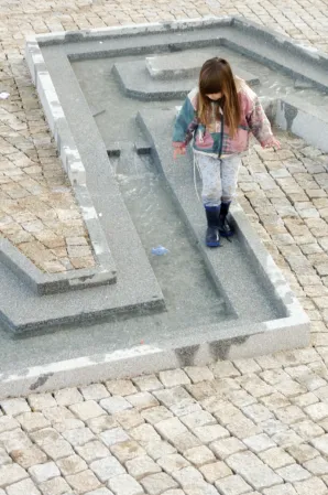 Kind spielt in einem Wasserspiel