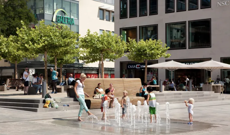 Fontänenfeld im Sommer mit spielenden Kindern