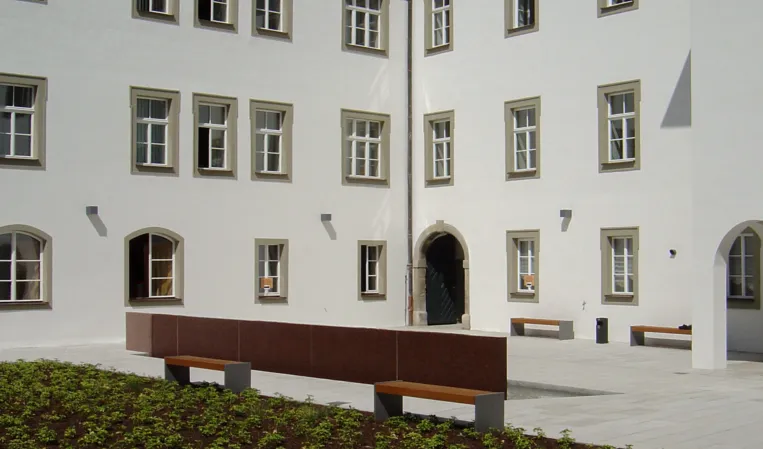 Rote Wasserwand in einem historischen Innenhof
