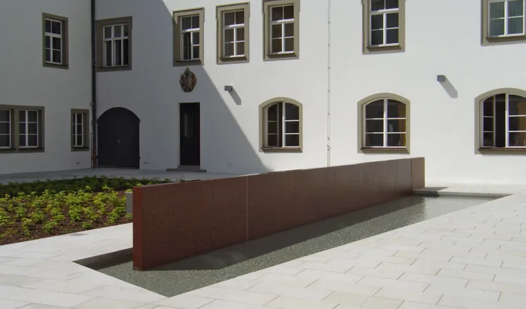 Rote Wasserwand in einem historischen Innenhof
