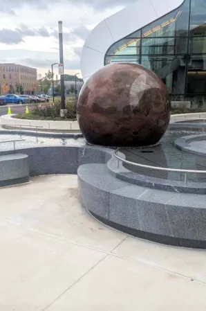 Rotbraune Granitkugel in einer Brunnenanlage