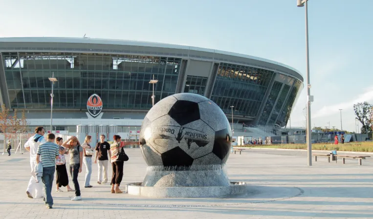 Schwimmende Kugel als Fussball vor einem Stadion