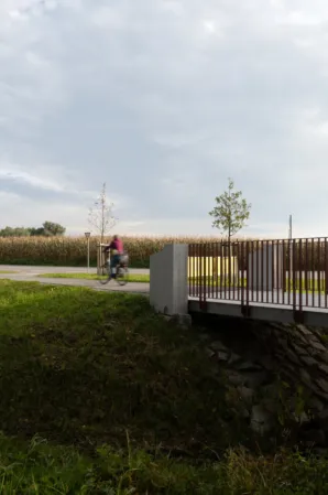 Radwegbrücke aus Granit mit Radfahrerin