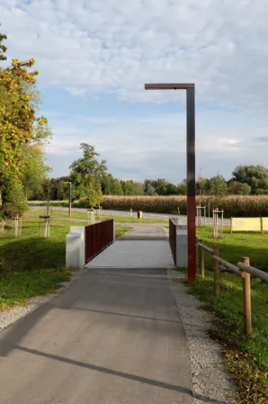 Radwegbrücke mit weinroten Geländer und großer Strassenlaterne