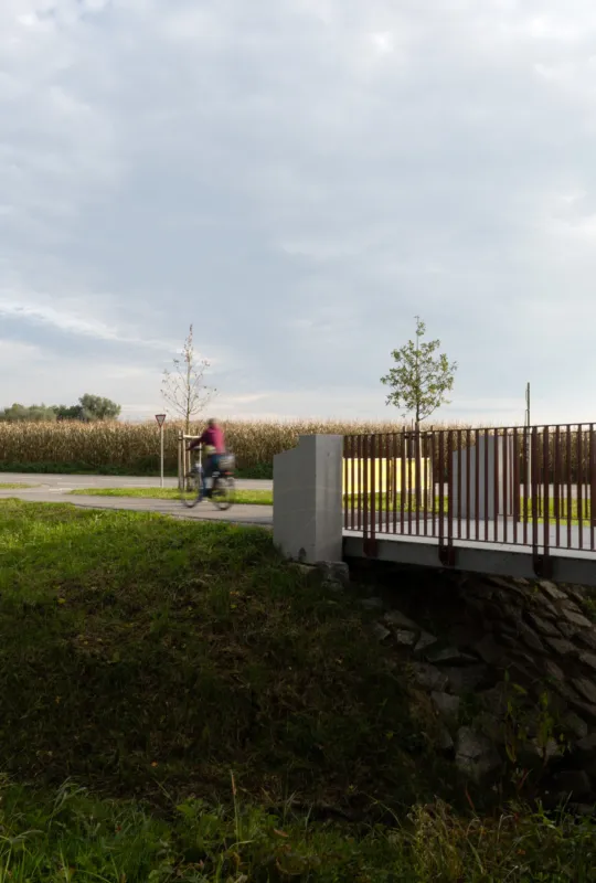 Radwegbrücke aus Granit mit Radfahrerin