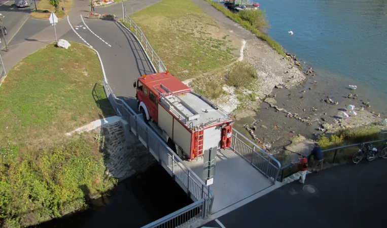 Feuerwehrauto fährt über Granitbrücke
