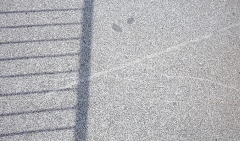 Textur einer Granitbrücke mit Schatten eines Geländers