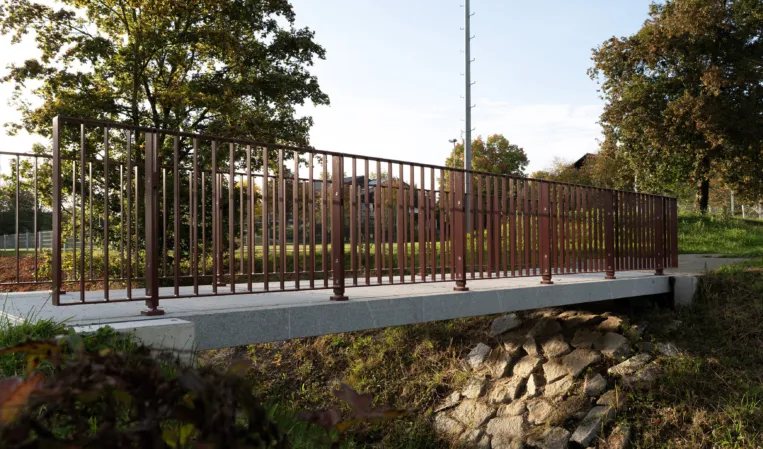 Fußgängerbrücke mit weinroten Geländer