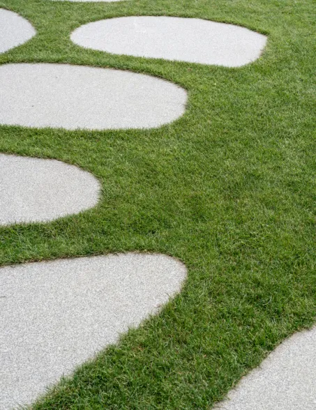 a pathway made out of boulder slices in a perfect lawn