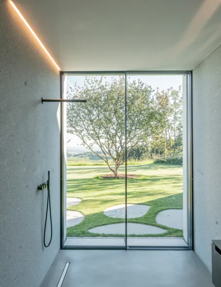 a bathroom with a openspace shower and a view into the garden