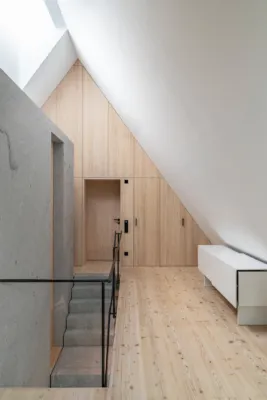 a interior shot of a modern house with a lot of wood surface and a solid granite wall