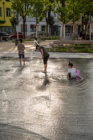 Kinder spielen in einem Fontänenfeld