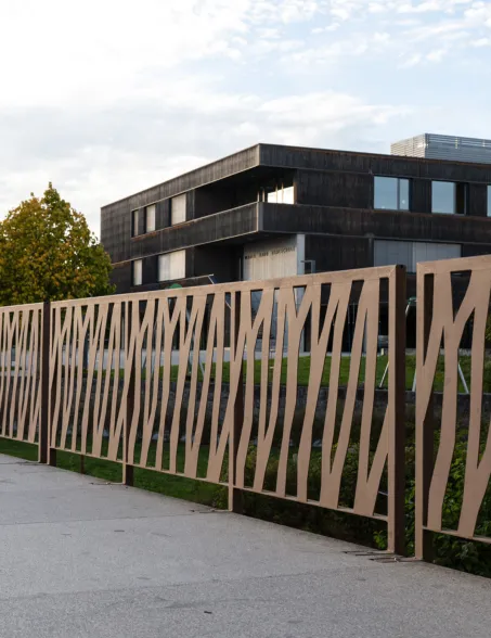 Geländer einer Brücke mit einem modernen Gebäude im Hintergrund