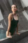 Schöne Frau taucht aus einem Pool aus Stein auf