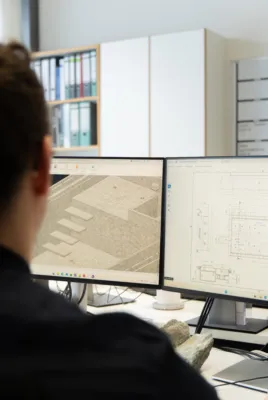 Mitarbeiter vor einem Monitor mit Konstruktionsprogramm