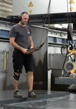 Arbeiter bedient eine Hebeanlage für Naturstein
