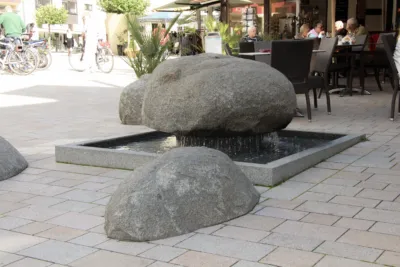 Brunnenanlage mit taumelnden Findlingen