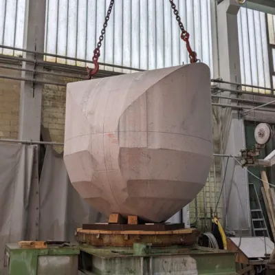Ein Rohblock der Stück für Stück in einen Ball gefräst wird.
