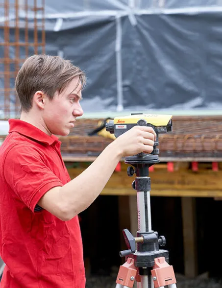 junger Mitarbeiter bedient Lasermessgerät